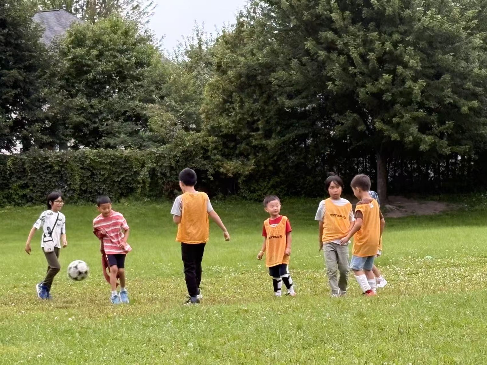 Children playing a soccer match in light rain