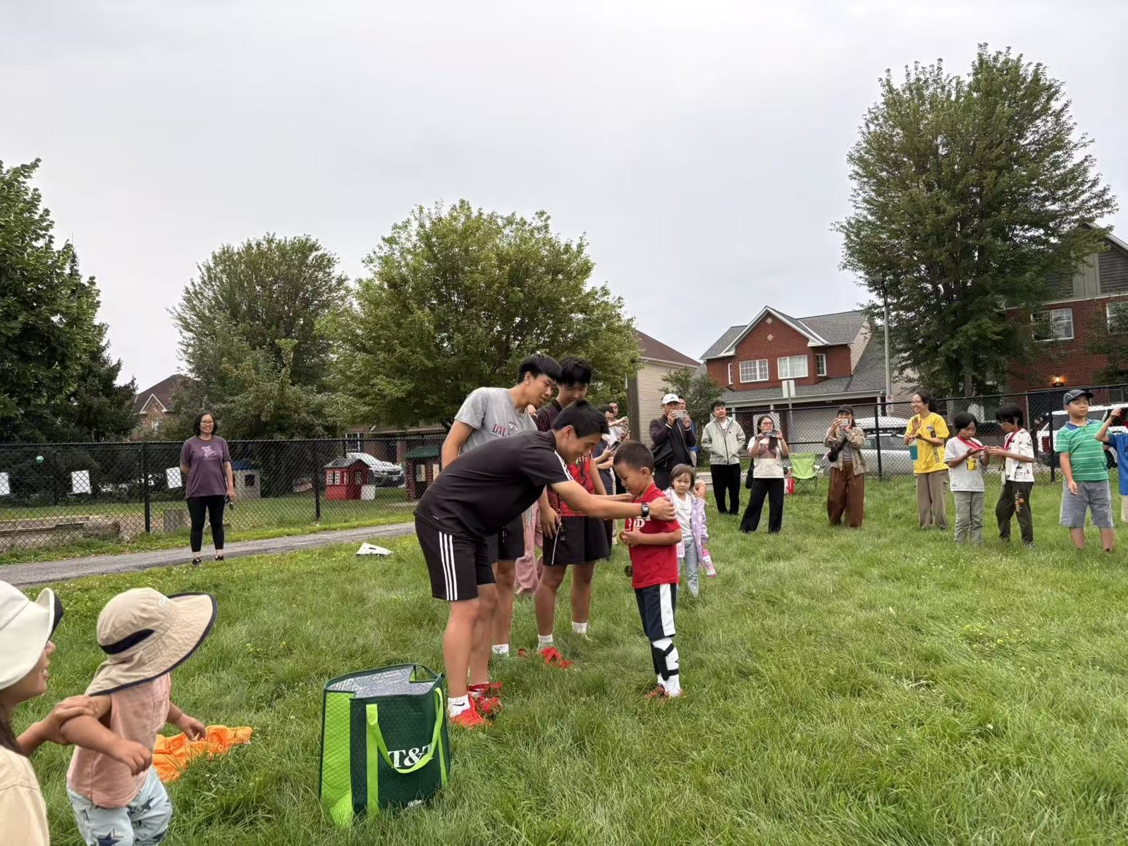 A coach giving a medal to a child after summer soccer